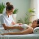 A pregnant woman receiving a gentle back massage from a therapist in a calm spa room with natural light and plants.